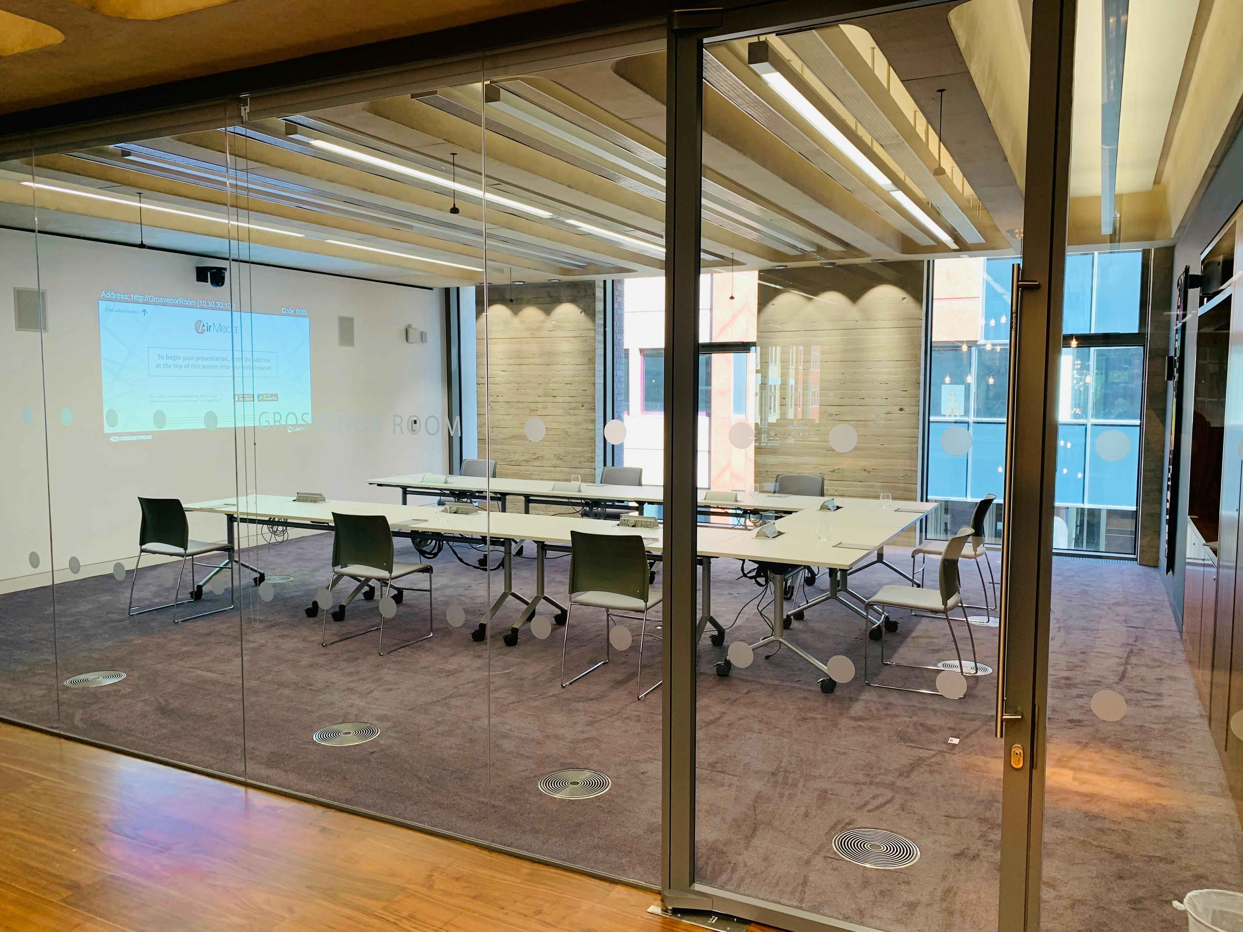 Modern meeting room with glass walls, ideal for collaborative events and presentations.