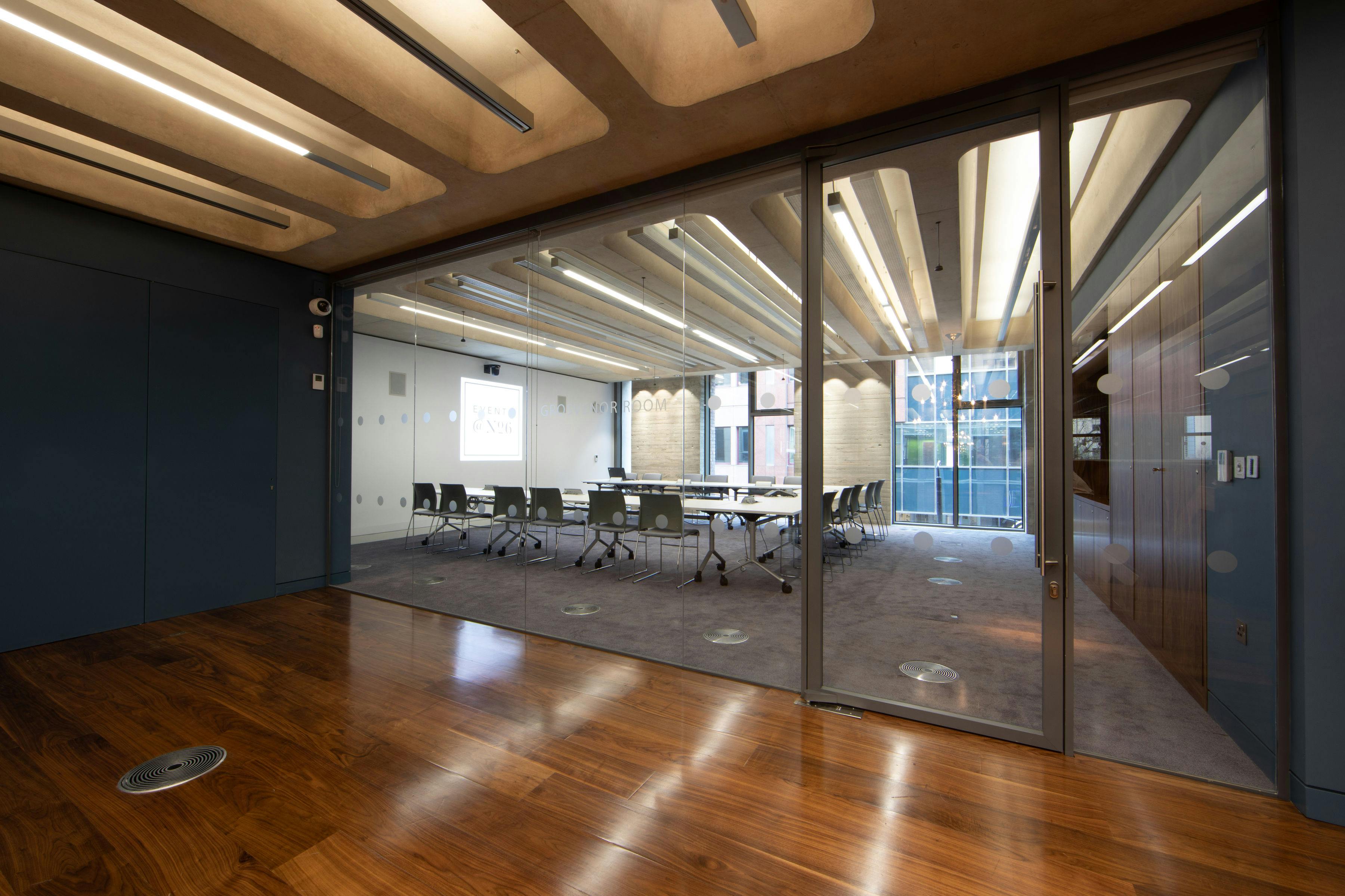 Modern Grosvenor Room with glass walls, ideal for meetings and hybrid events.