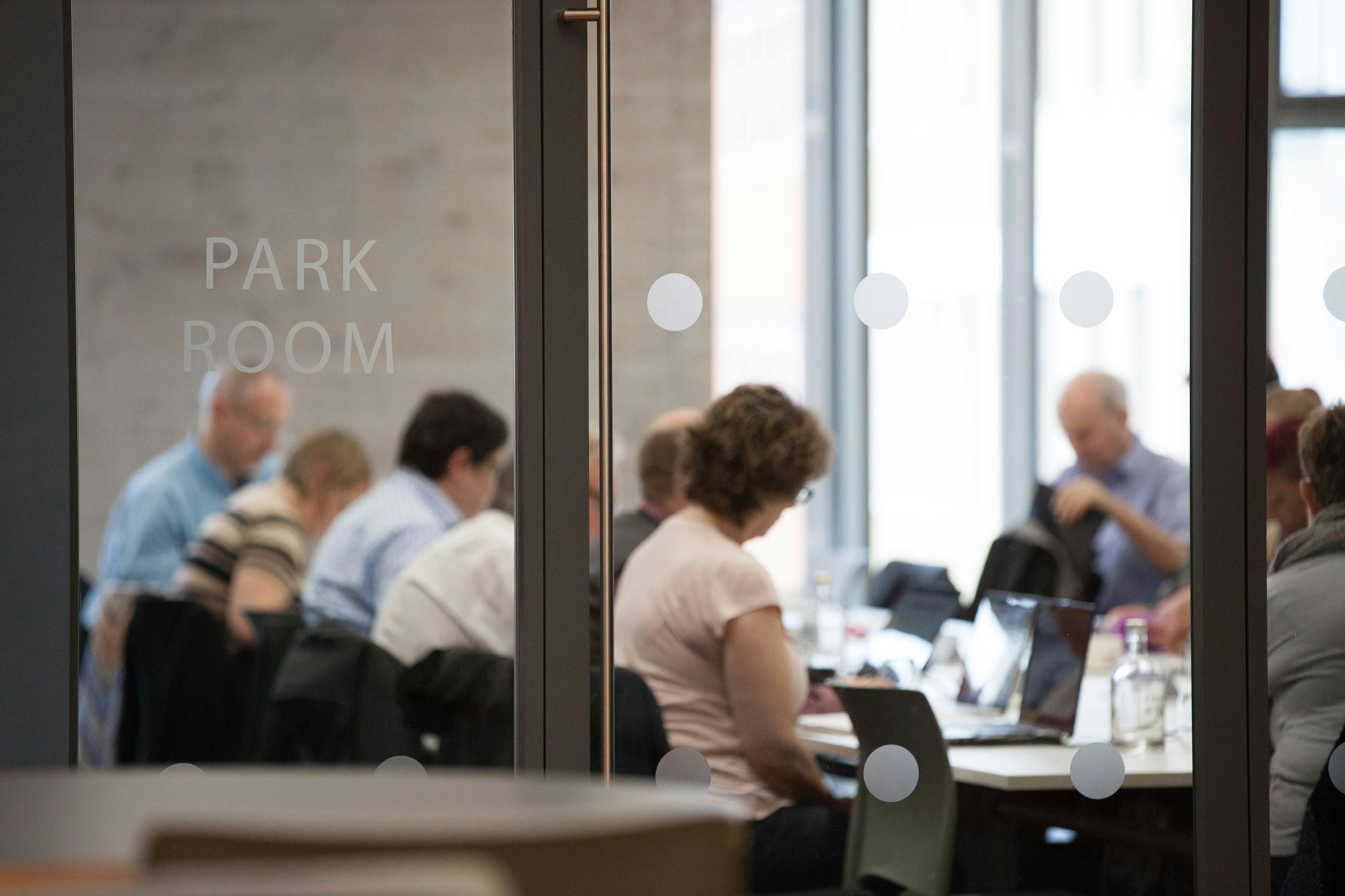 Professional meeting in Park Room, featuring glass walls for collaboration and creativity.