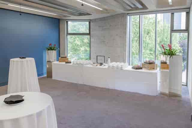 Elegant Park Room event space with high-top tables and natural light for corporate gatherings.