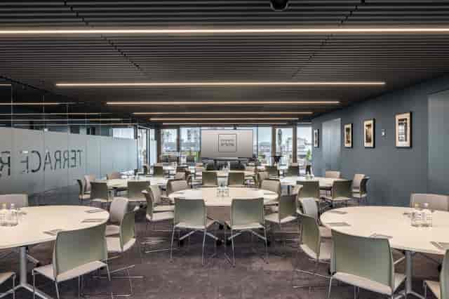 Modern event space with round tables, ideal for corporate meetings and workshops.