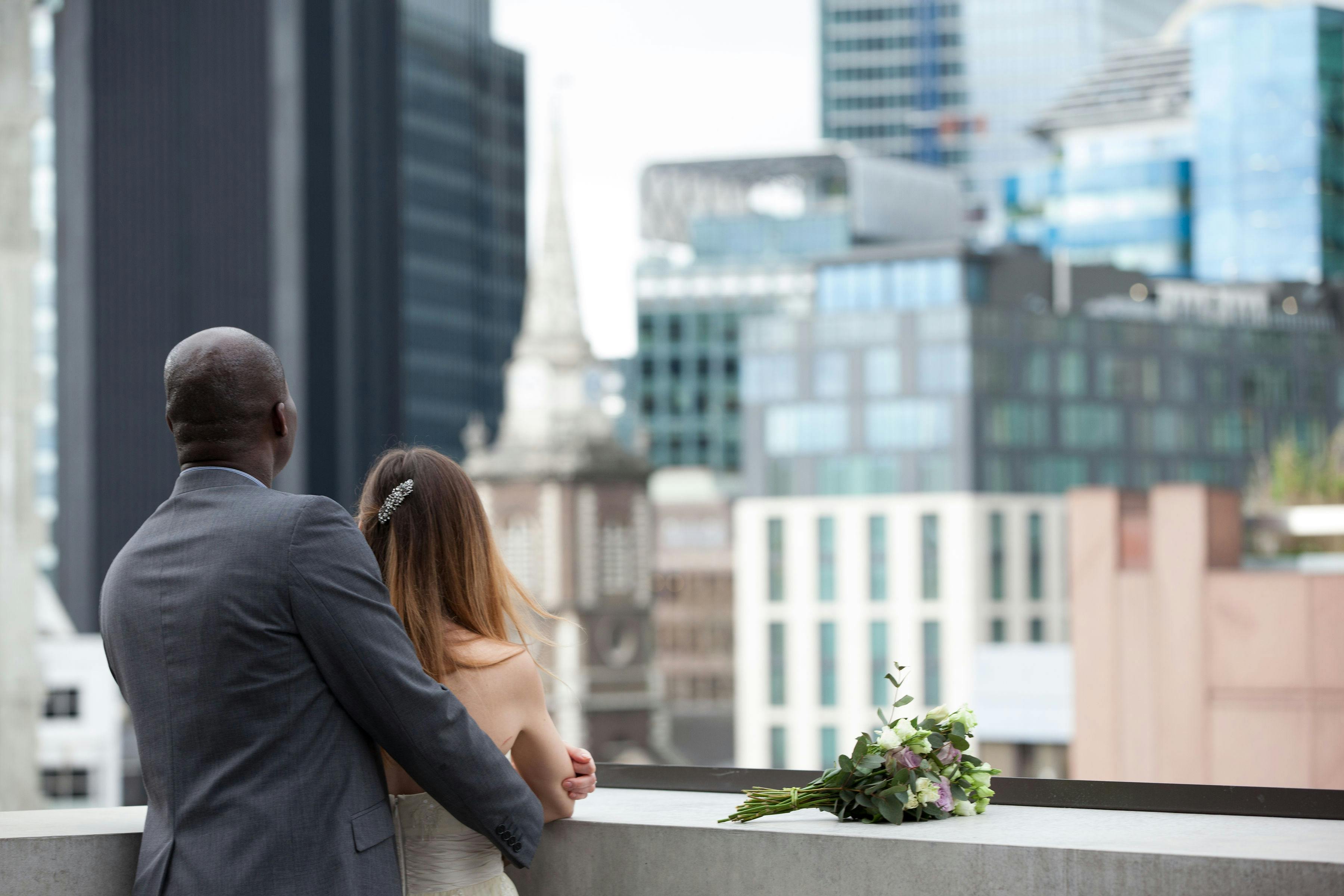 Couple on rooftop terrace with city skyline, ideal for weddings and corporate events.