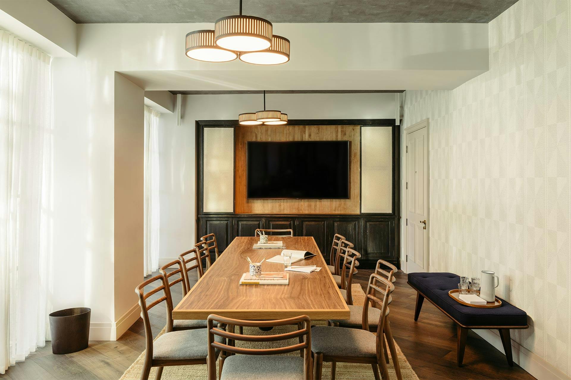 Modern meeting room at The Hoxton Southwark with spacious table and large screen.