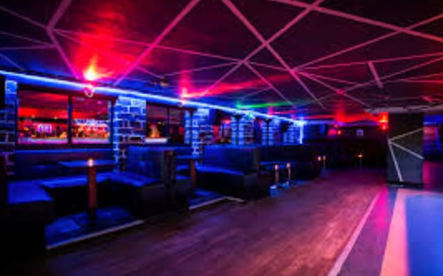 Modern dance bar with vibrant blue lighting, perfect for networking events and social gatherings.