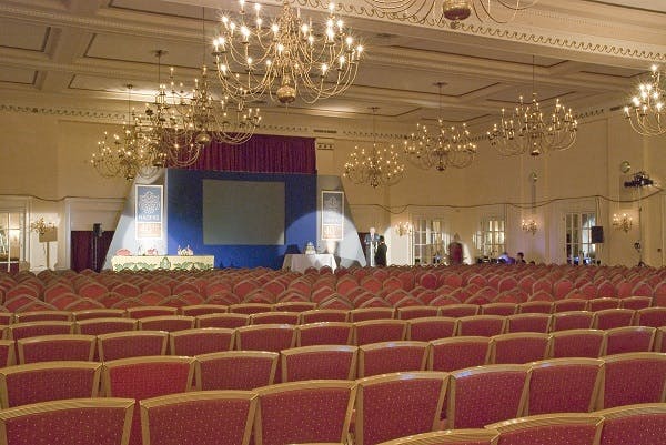 Banqueting Hall at The Adelphi Hotel, elegant conference setup with red chairs and chandelier.