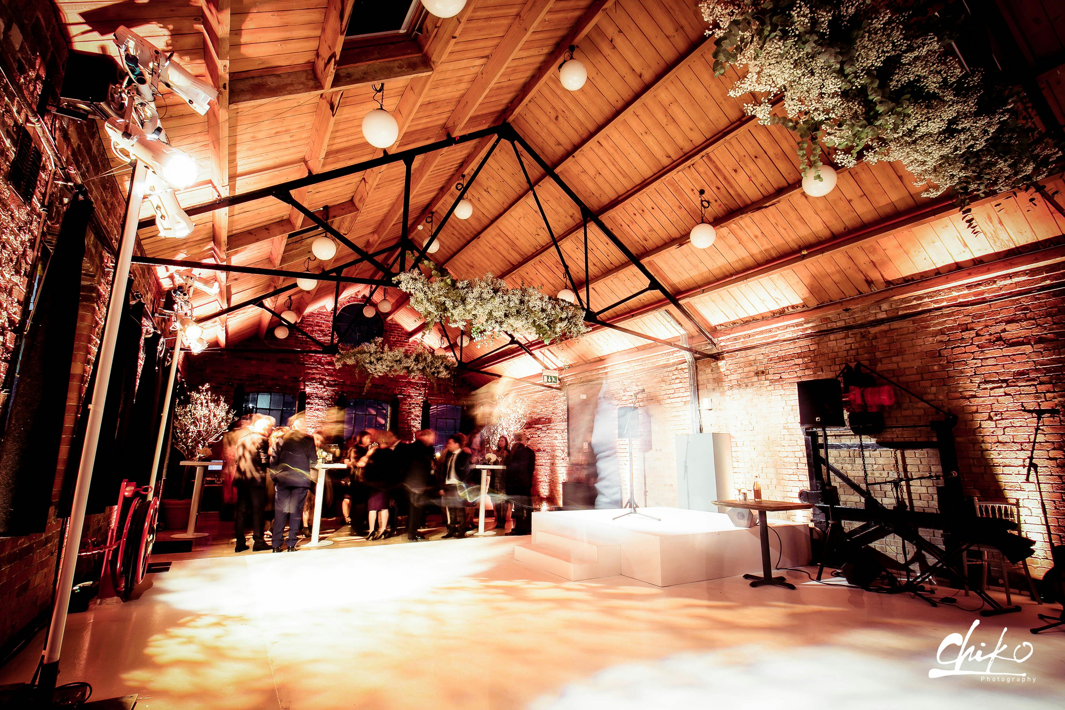 Elegant Loft Studios event space with exposed brick and wooden ceiling for networking.