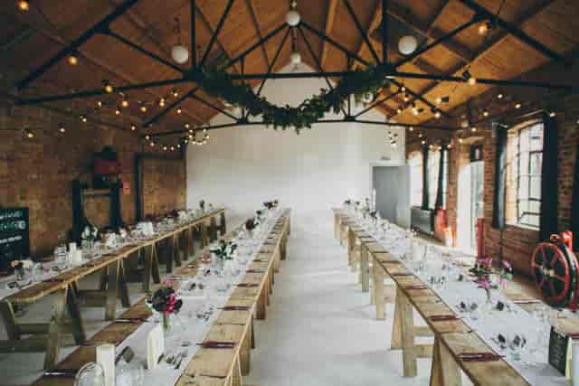 Elegant event space with wooden tables, ideal for corporate gatherings and celebrations.