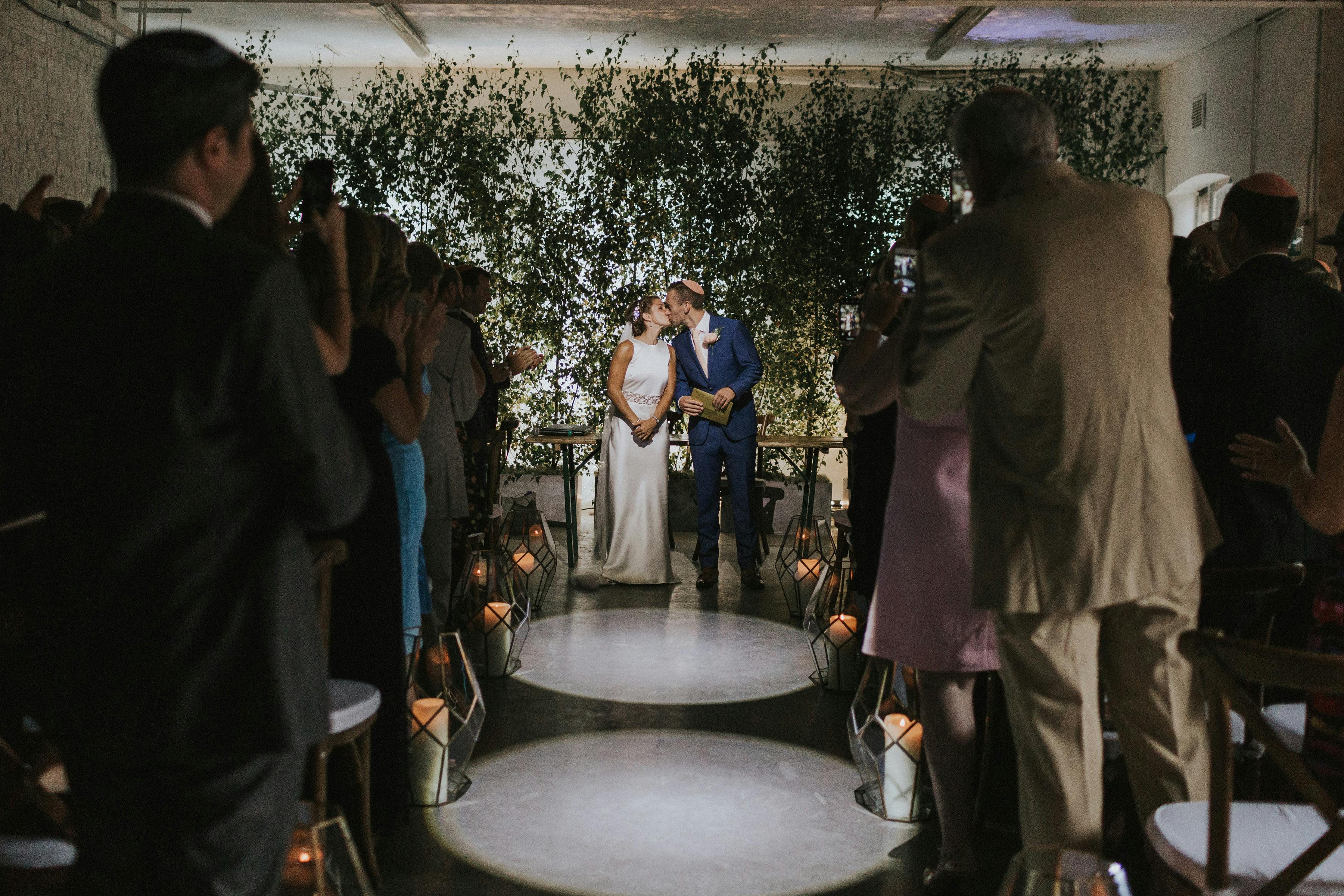 Intimate wedding ceremony in Studio 5, Loft Studios with lush floral backdrop.