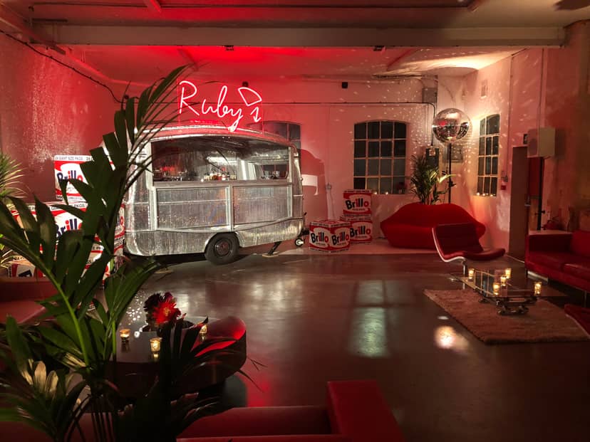 Stylish Loft Studios event space with vintage food truck and modern seating for gatherings.