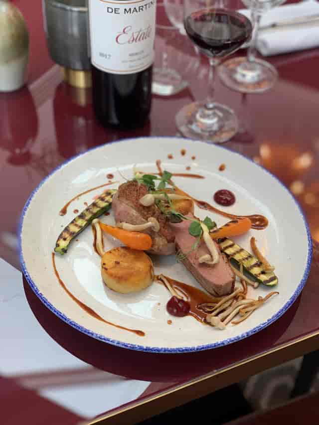 Gourmet meat dish with vibrant vegetables at Aldwyn's, perfect for upscale events.