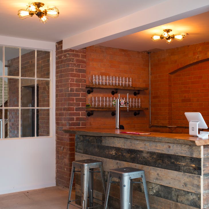 Stylish bar with rustic wood counter, ideal for networking events and cocktail receptions.