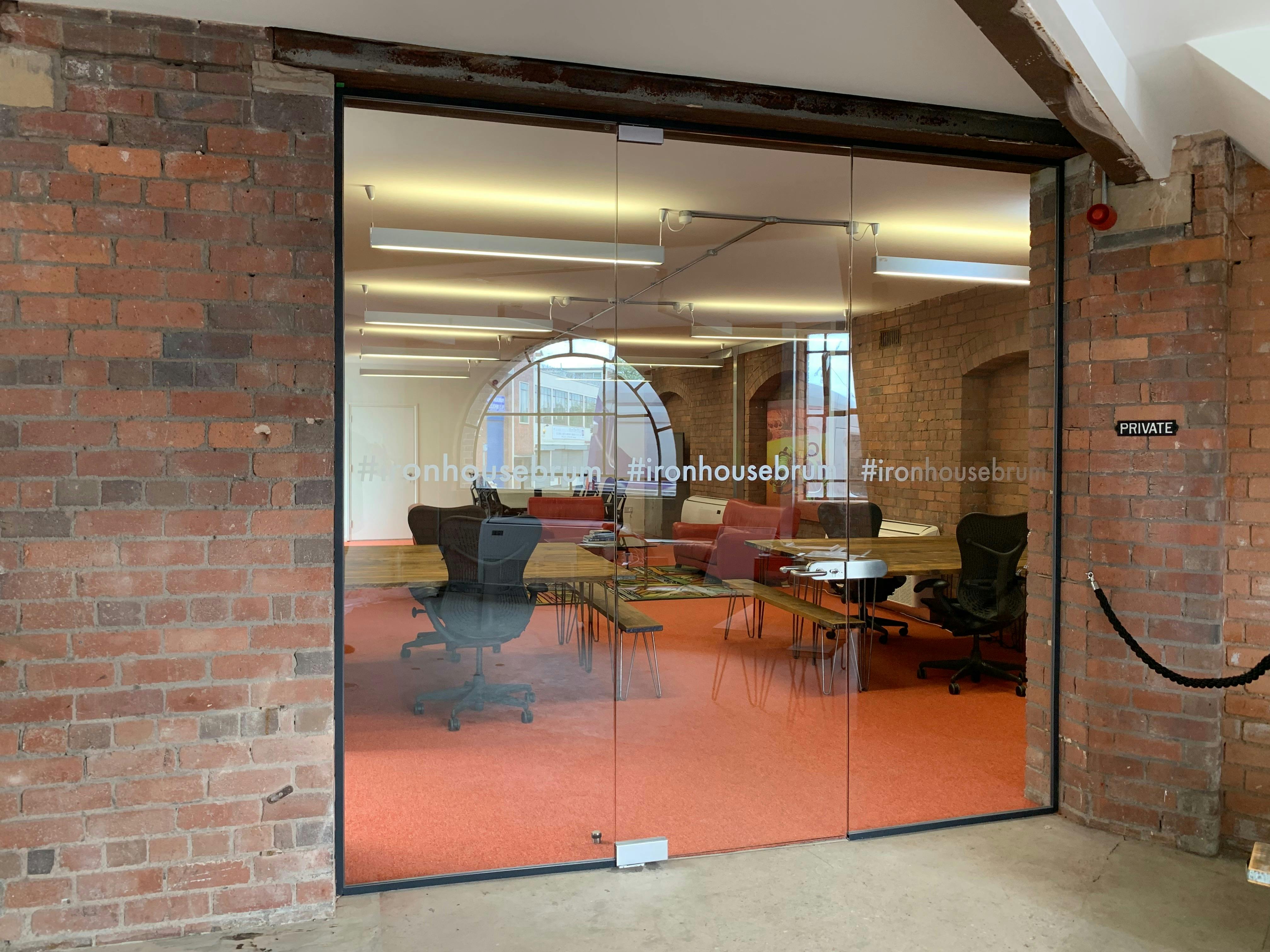 Modern meeting space in Iron House with glass entrance, ideal for workshops and team meetings.