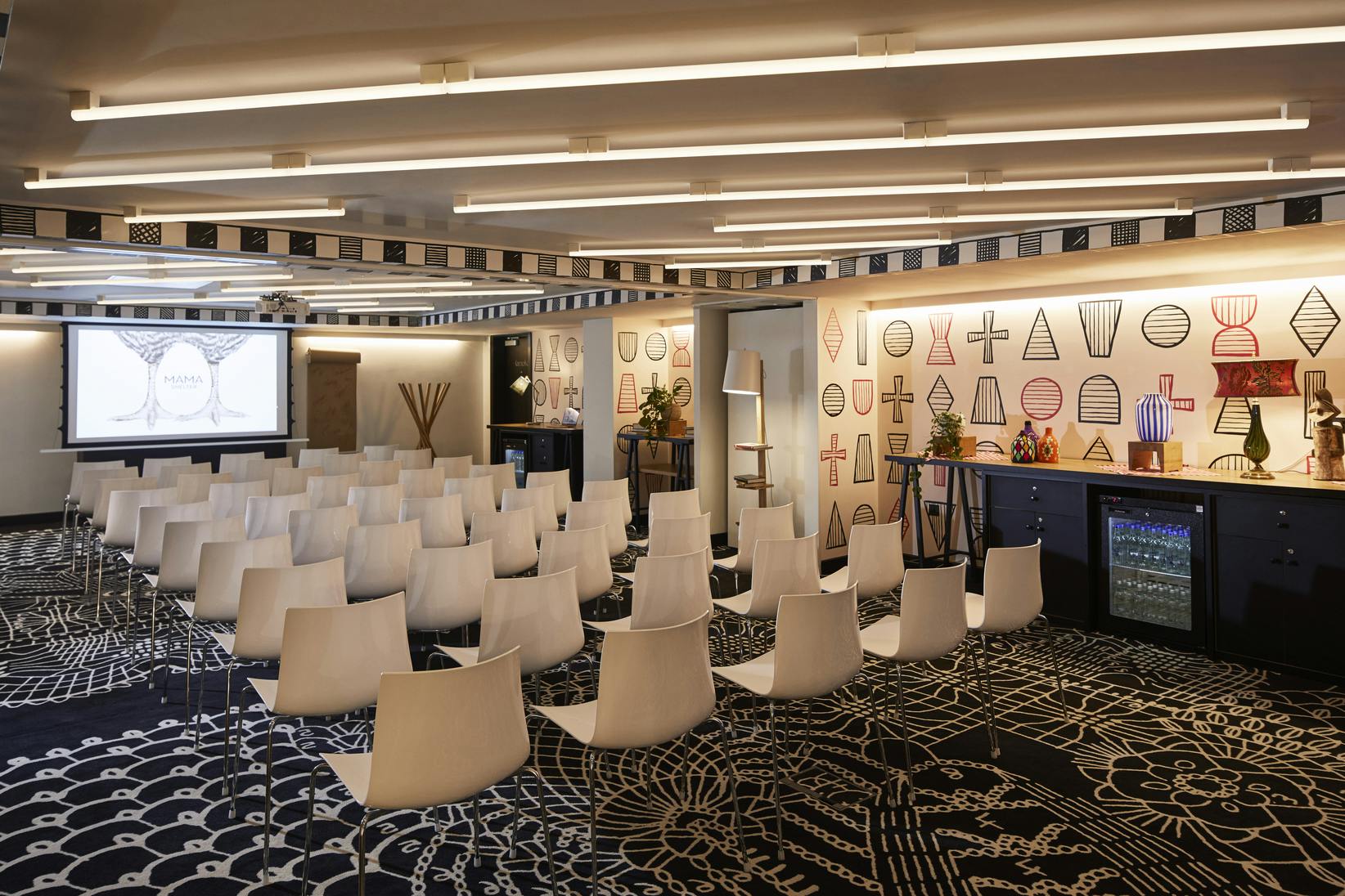 Modern event space at Mama Shelter London with white chairs for meetings and presentations.