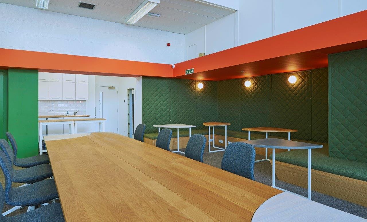 Conference Hall in Whitechapel Hub with wooden table, ideal for workshops and meetings.