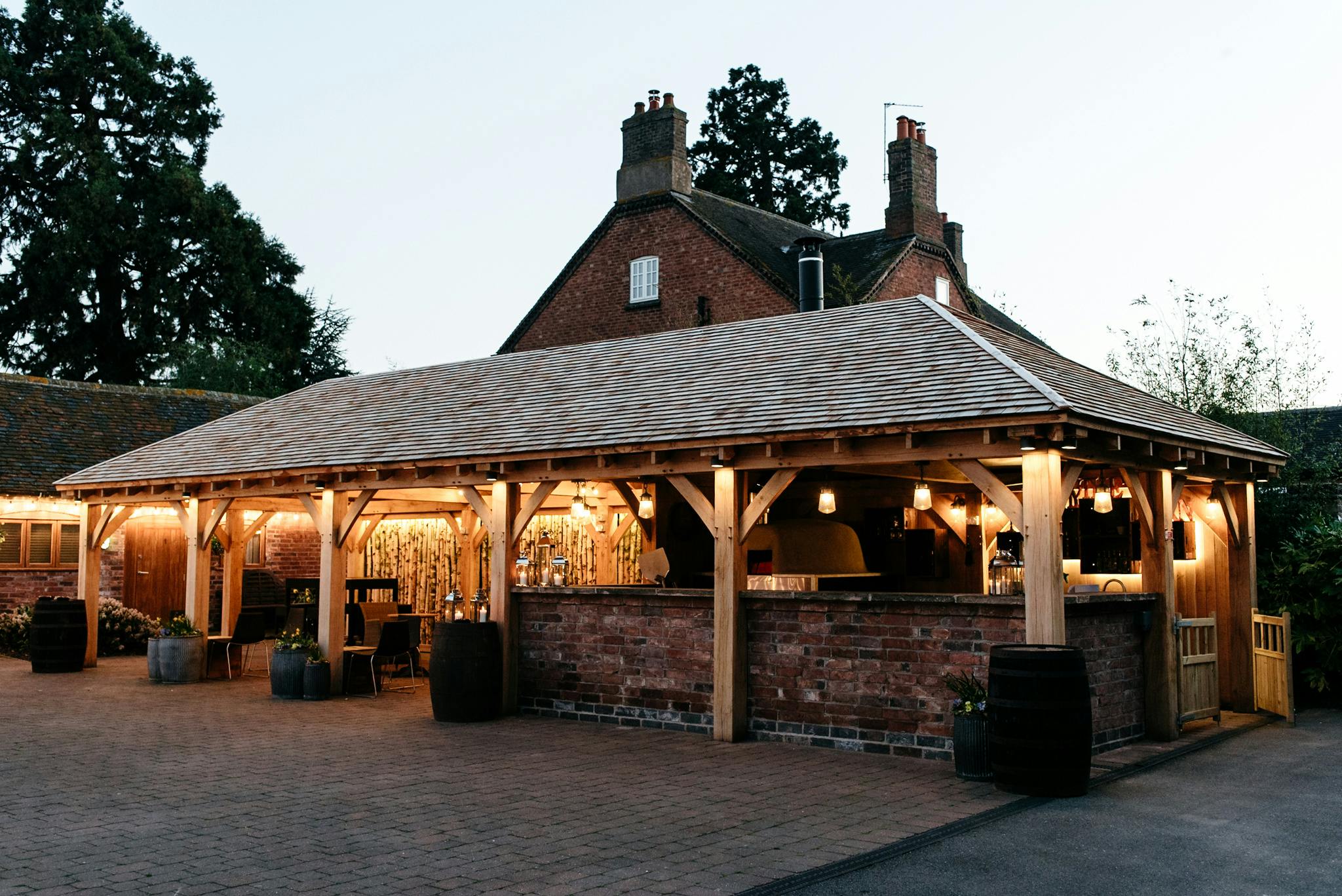 Charming outdoor venue at Mythe Barn, ideal for weddings and events with rustic wooden structure.