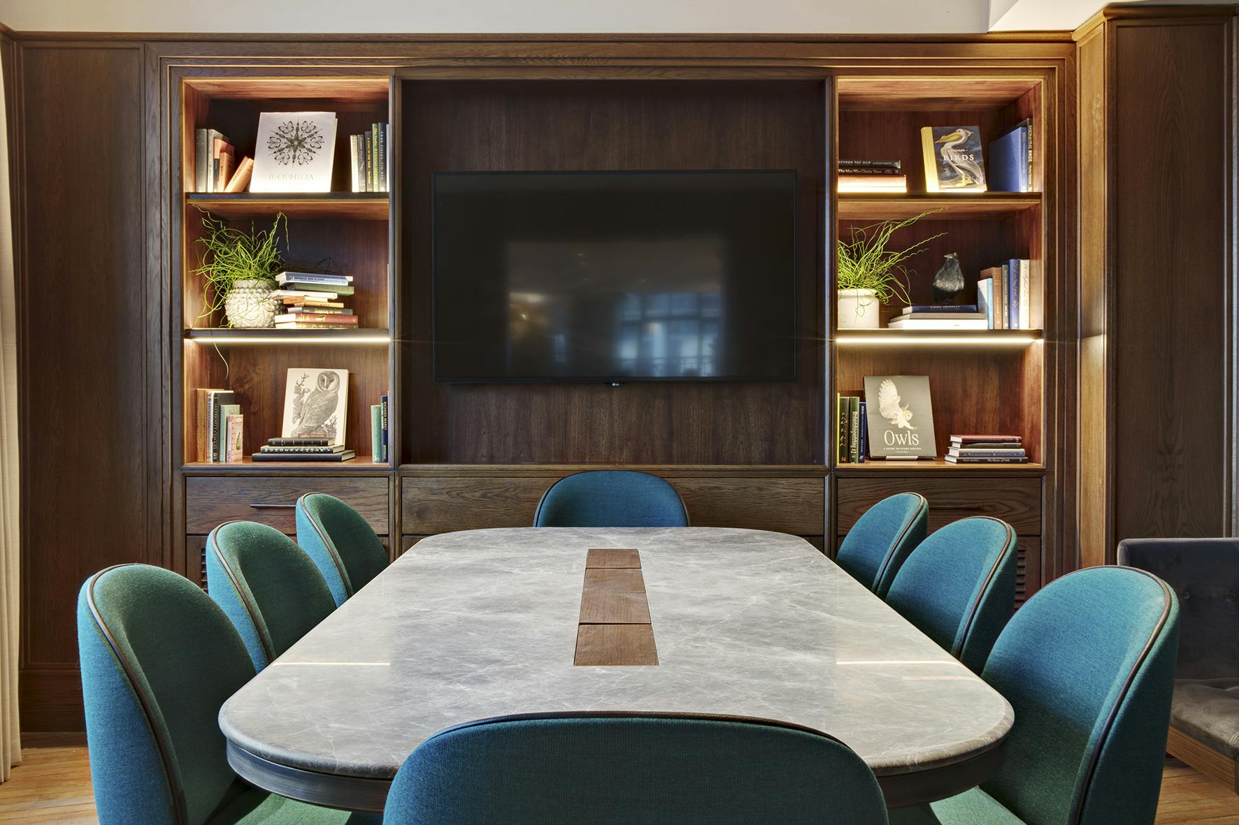 Private dining room with marble table and teal chairs, perfect for meetings or gatherings.