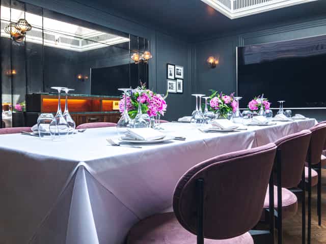 Elegant dining table with pink chairs for corporate events in Les Platanes.