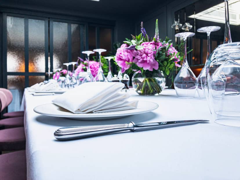 Elegant dining table setup with floral centerpieces for formal dinner or corporate event.