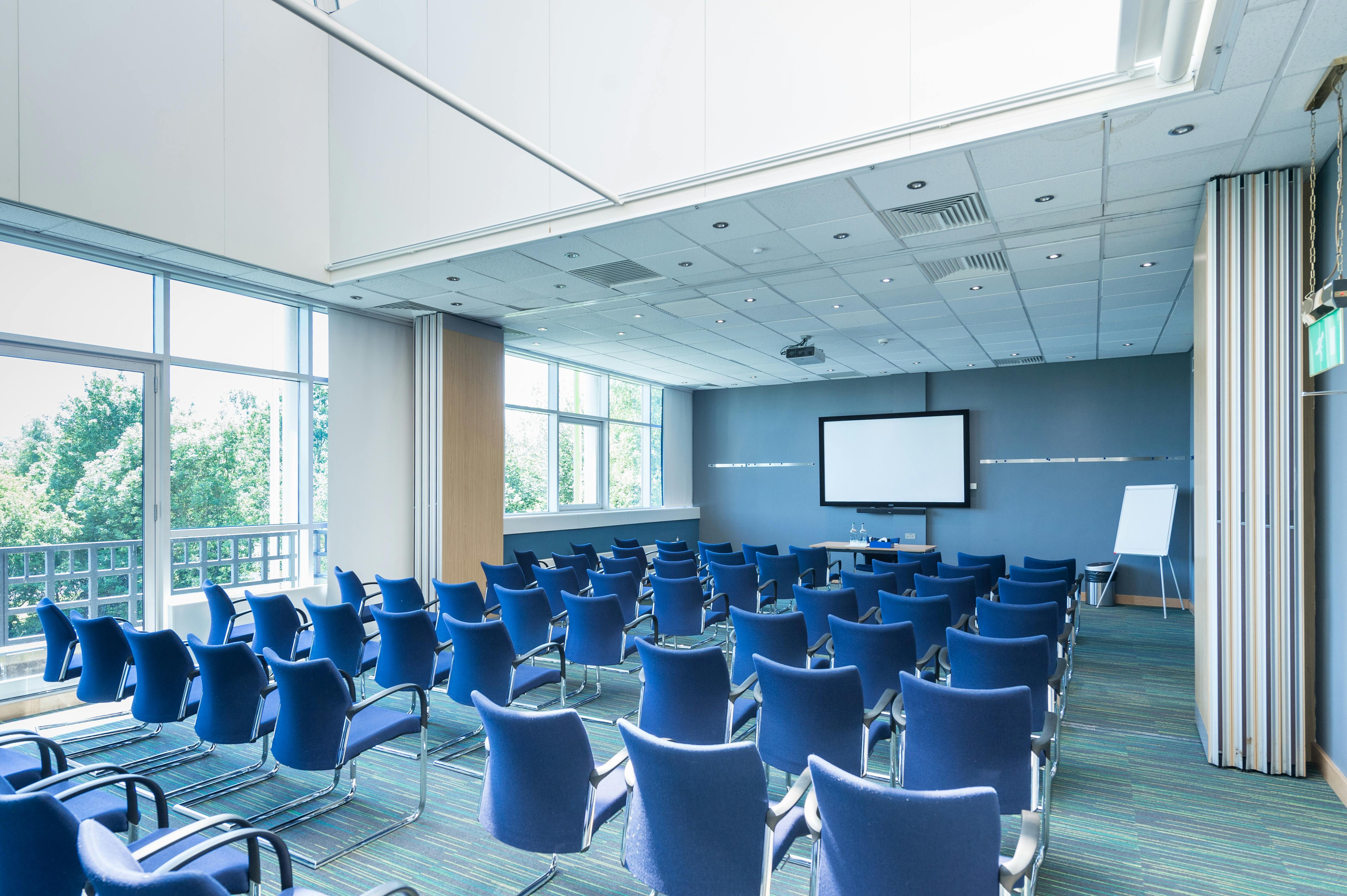 Brunel conference room with blue chairs, ideal for workshops and corporate meetings.