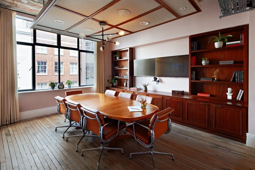 Modern conference room with wooden table, ideal for meetings and presentations.