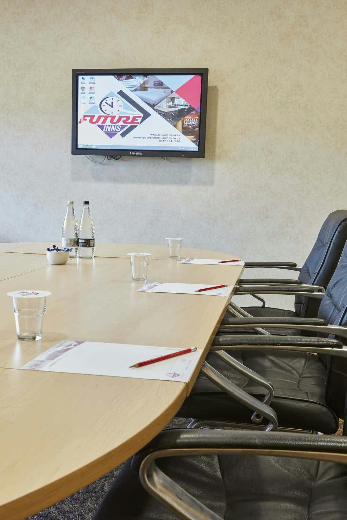 Meeting room at Future Inn Bristol with round table, water bottles, and notepads.