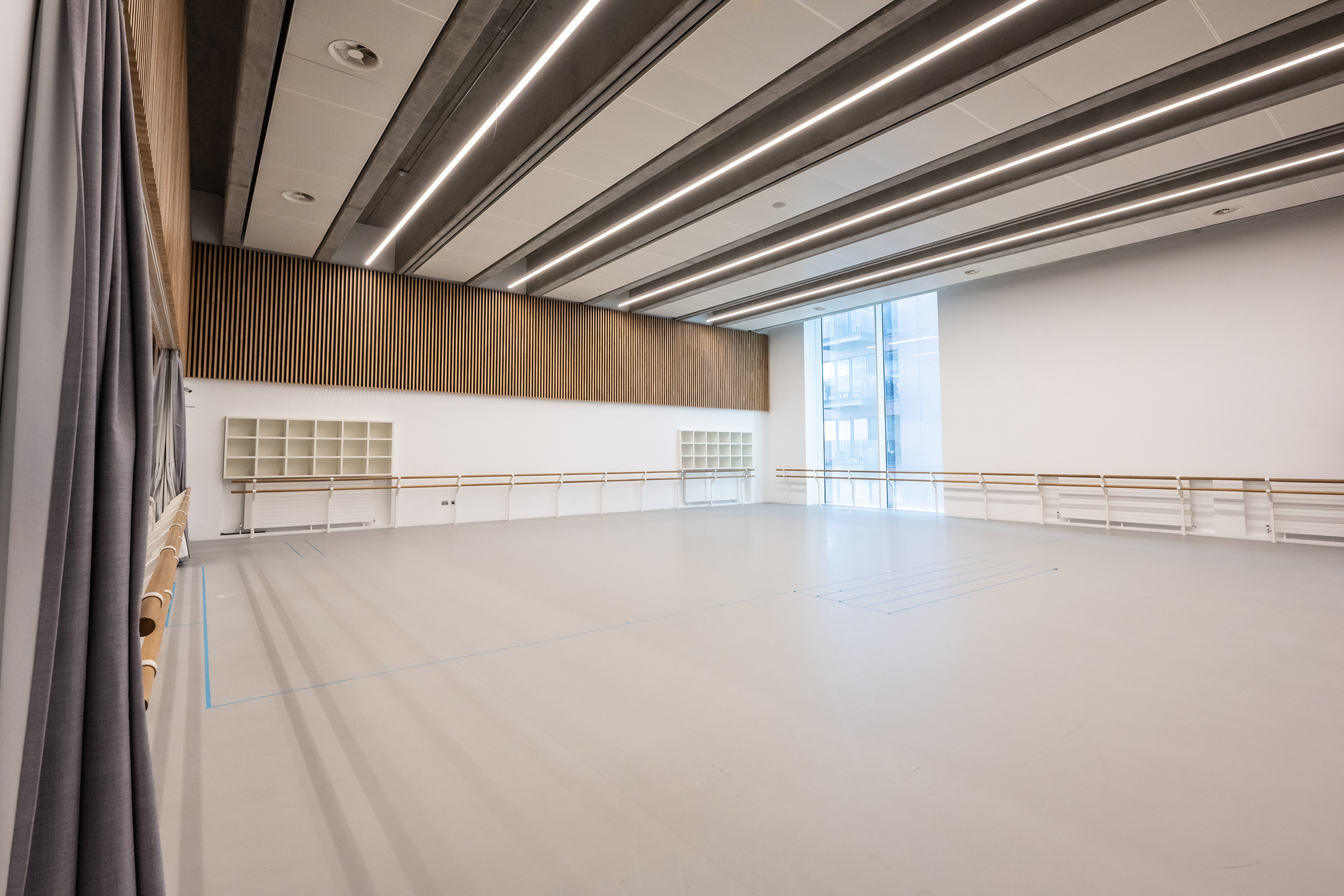 Spacious rehearsal studio with large windows, ideal for workshops and corporate events. - Banner