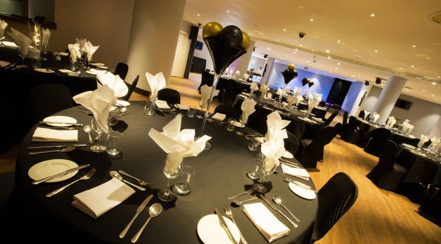 Elegant event space at Alea Casino, set for a formal dinner with black tablecloths.