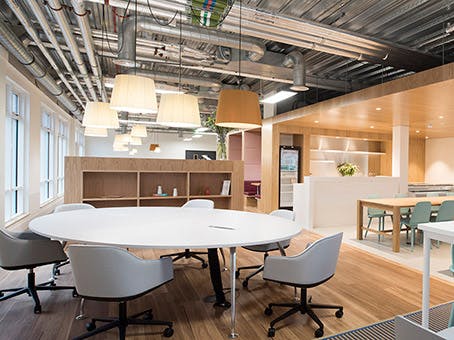 Modern open meeting space with circular table for collaborative brainstorming sessions.