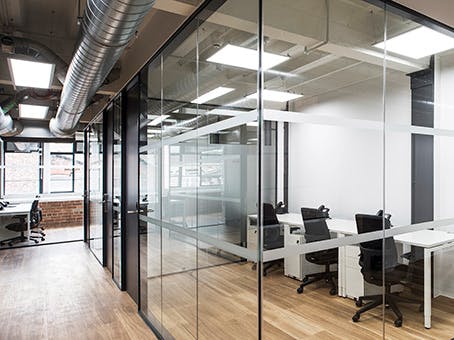 Modern open office space with glass walls for collaborative meetings and events.