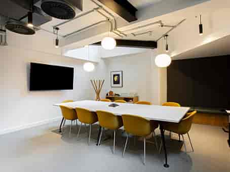 Modern meeting room with yellow chairs, ideal for brainstorming and strategic sessions.