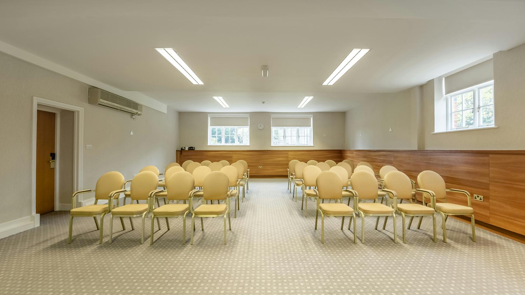 Meeting room at The Elvetham, Hampshire with beige chairs for workshops and presentations.