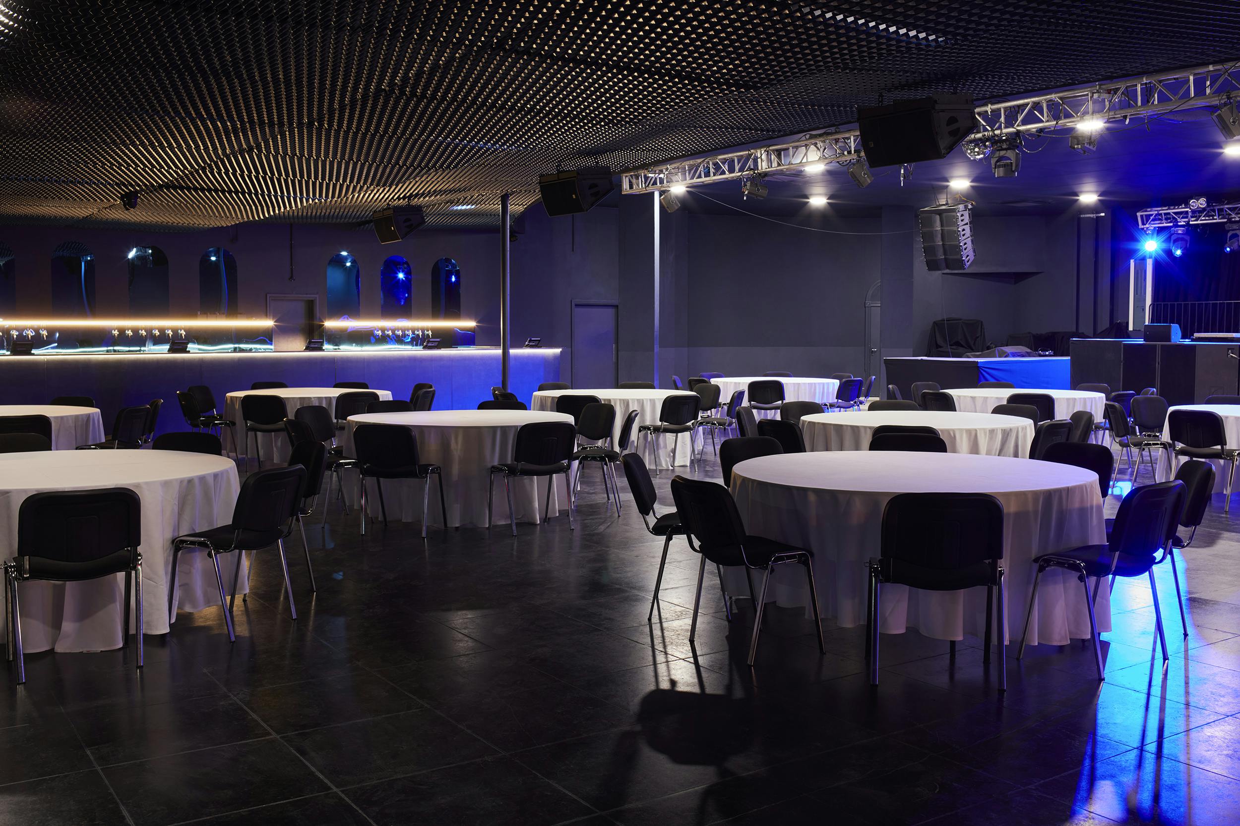 Versatile Concert Hall in EartH with round tables, ideal for banquets and networking events.