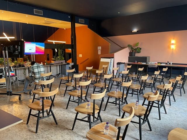 Versatile event space at Bar + Kitchen, EartH, set for a meeting with wooden chairs.