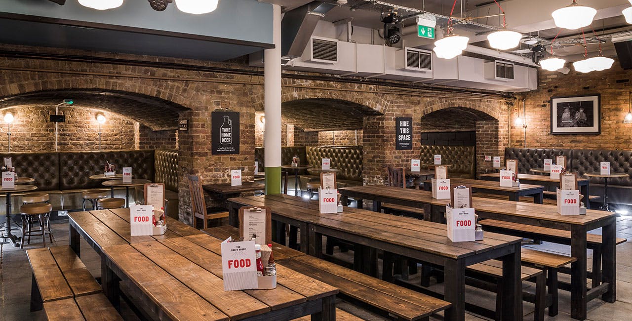 Spacious Beer Hall with rustic tables, perfect for casual dining and networking events.