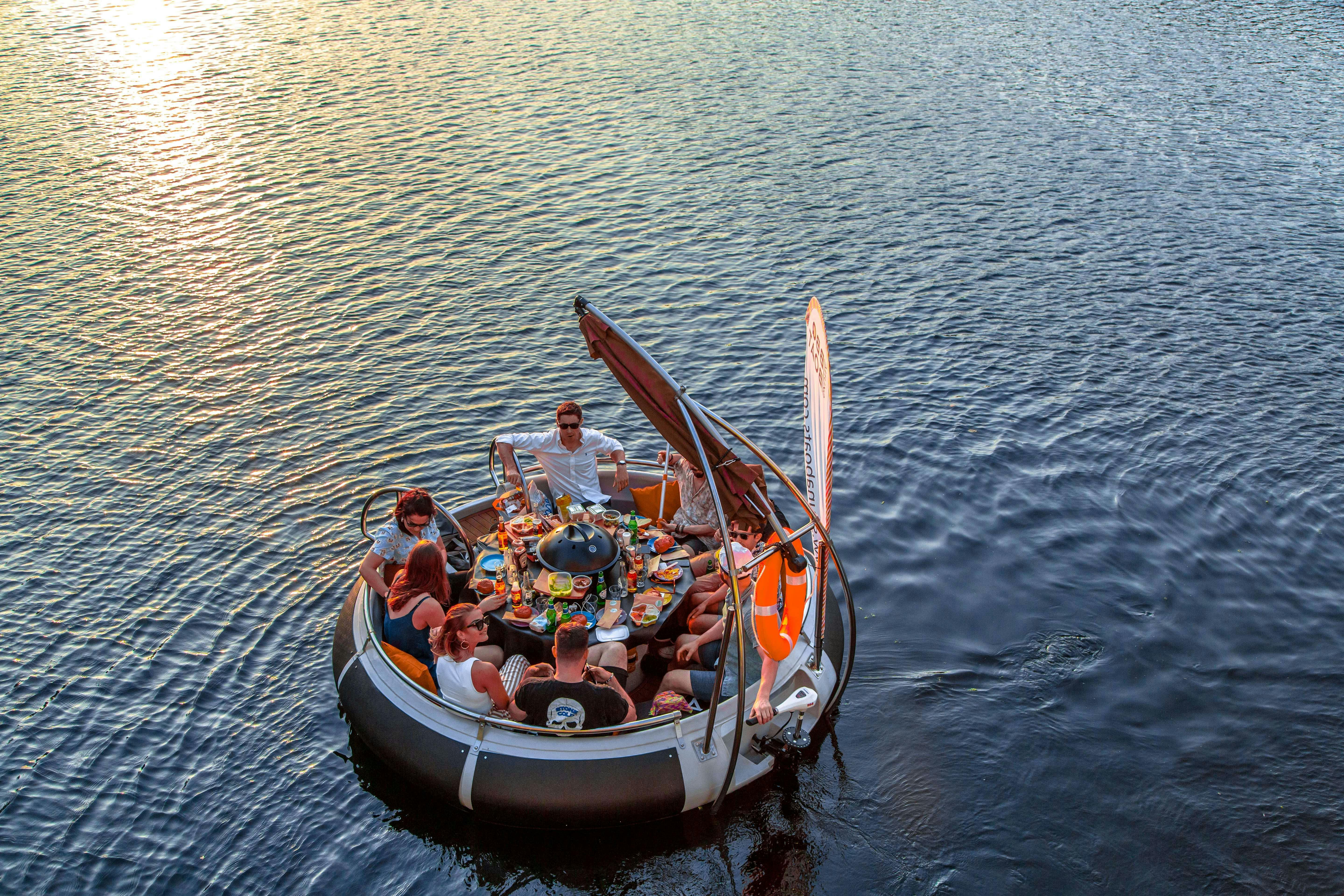 BBQ Boat on water, circular seating for team-building and corporate retreats.