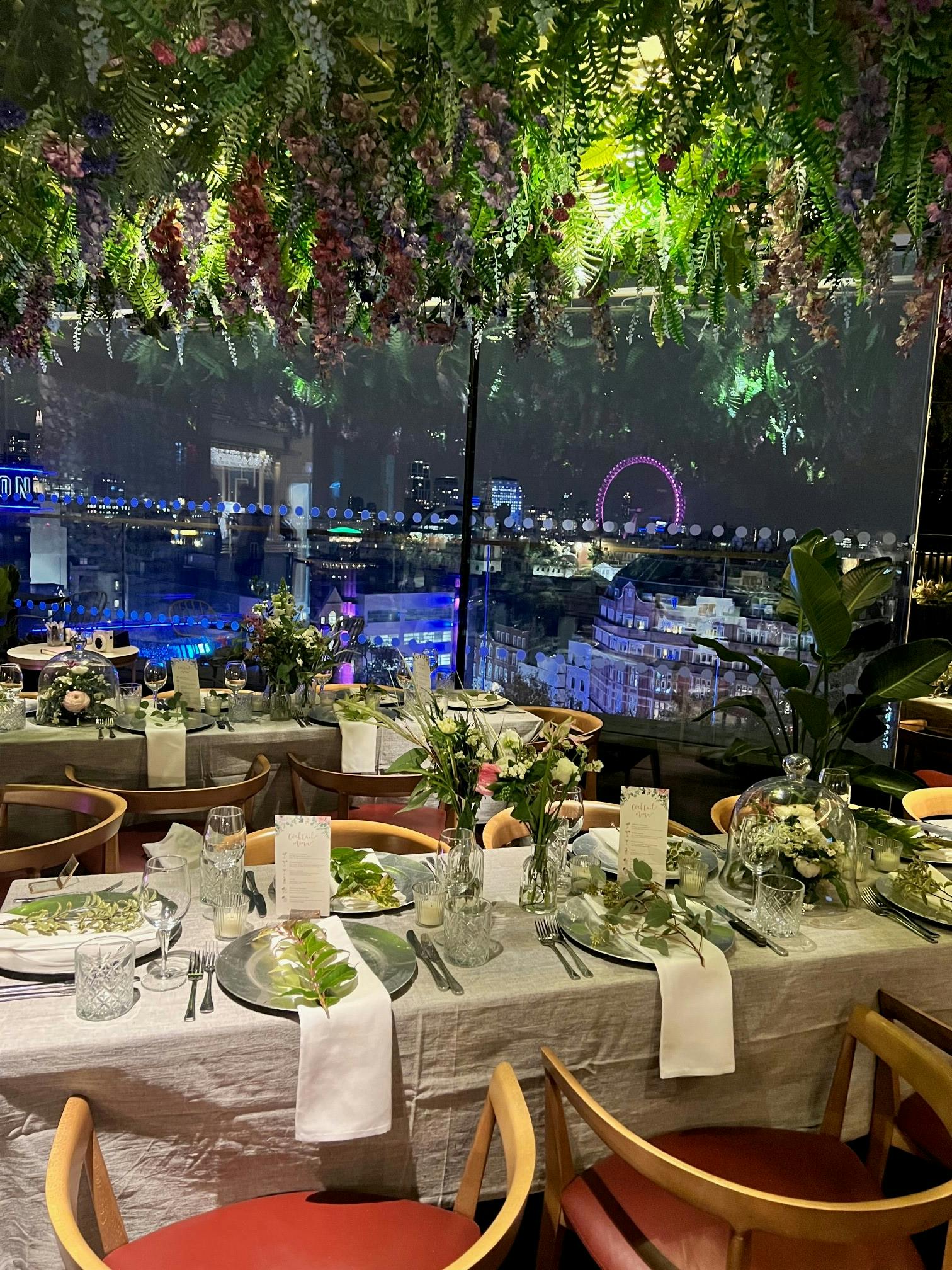 Elegant dining table with floral arrangements at LSQ Rooftop, perfect for upscale events.