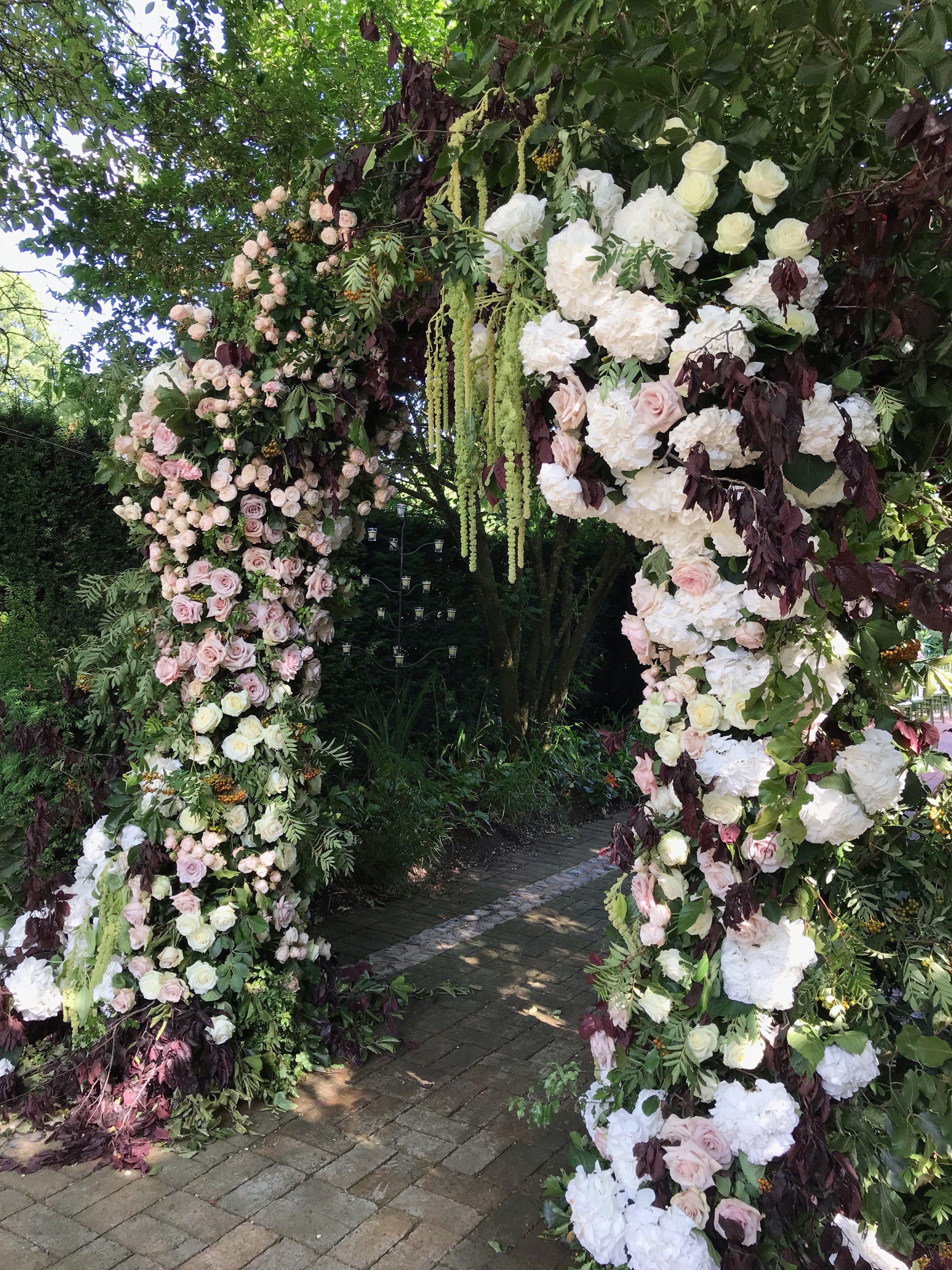 Floral archway at La Goccia, perfect for weddings and garden parties in Covent Garden. - Banner