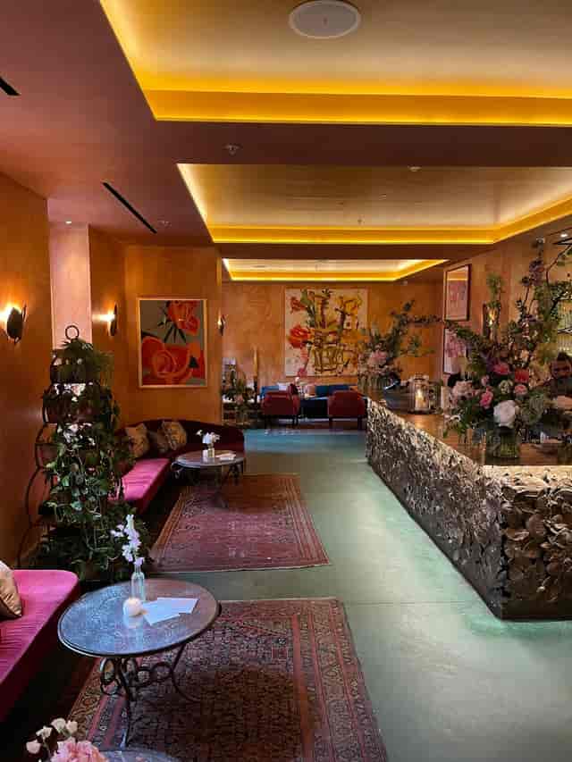 Stylish event space at La Goccia, featuring warm orange walls and floral decor.