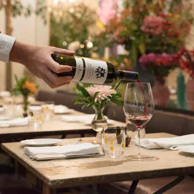 Elegant wine pouring at La Goccia, Petersham Nurseries, for upscale dining events.