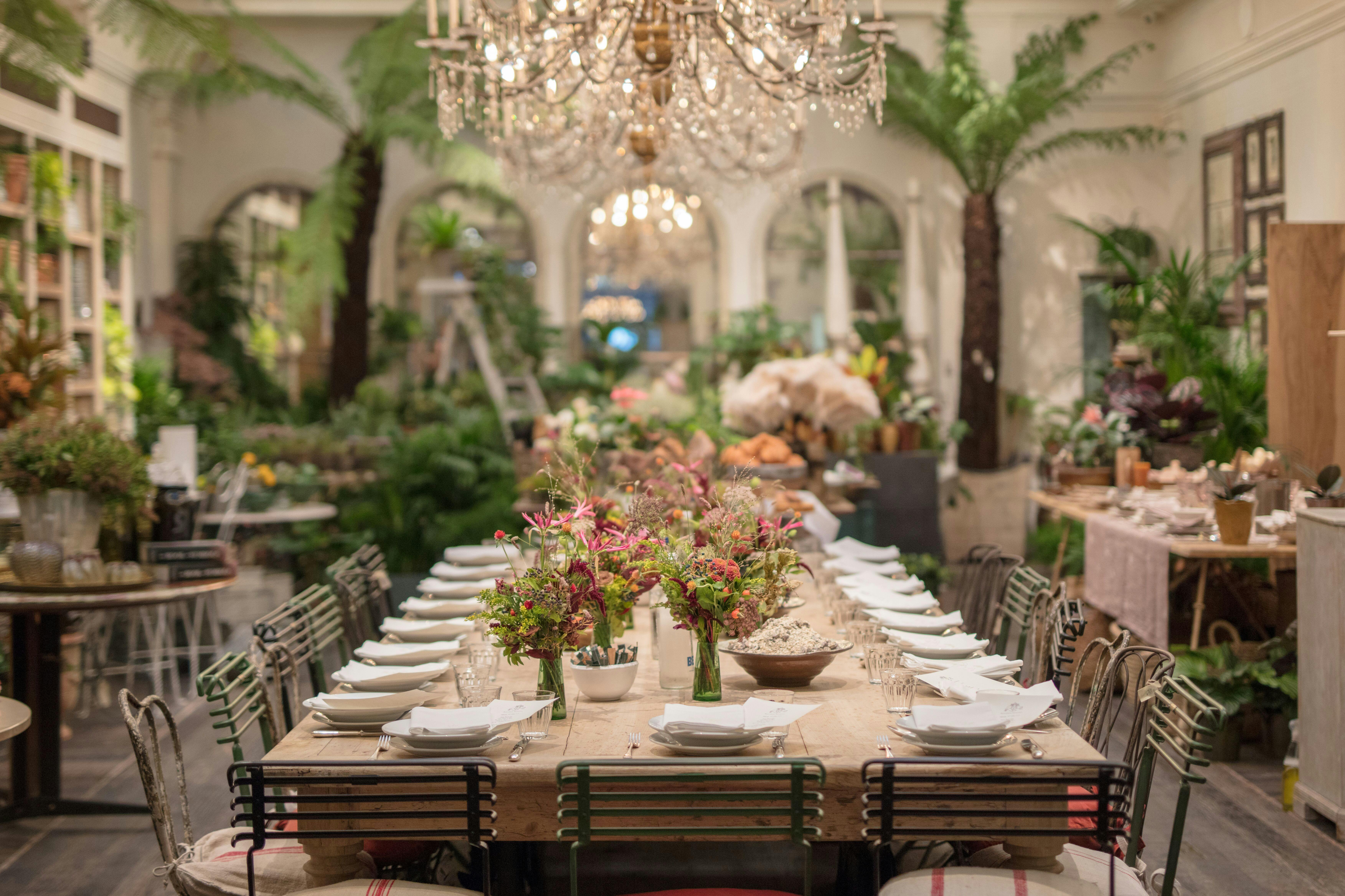Elegant dining setup with floral centerpieces at Petersham Nurseries event space.