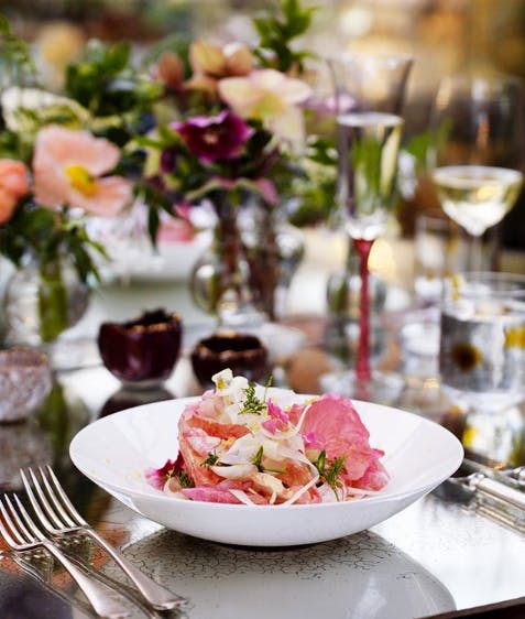 Elegant dining table with floral arrangements at Petersham Nurseries for upscale events.
