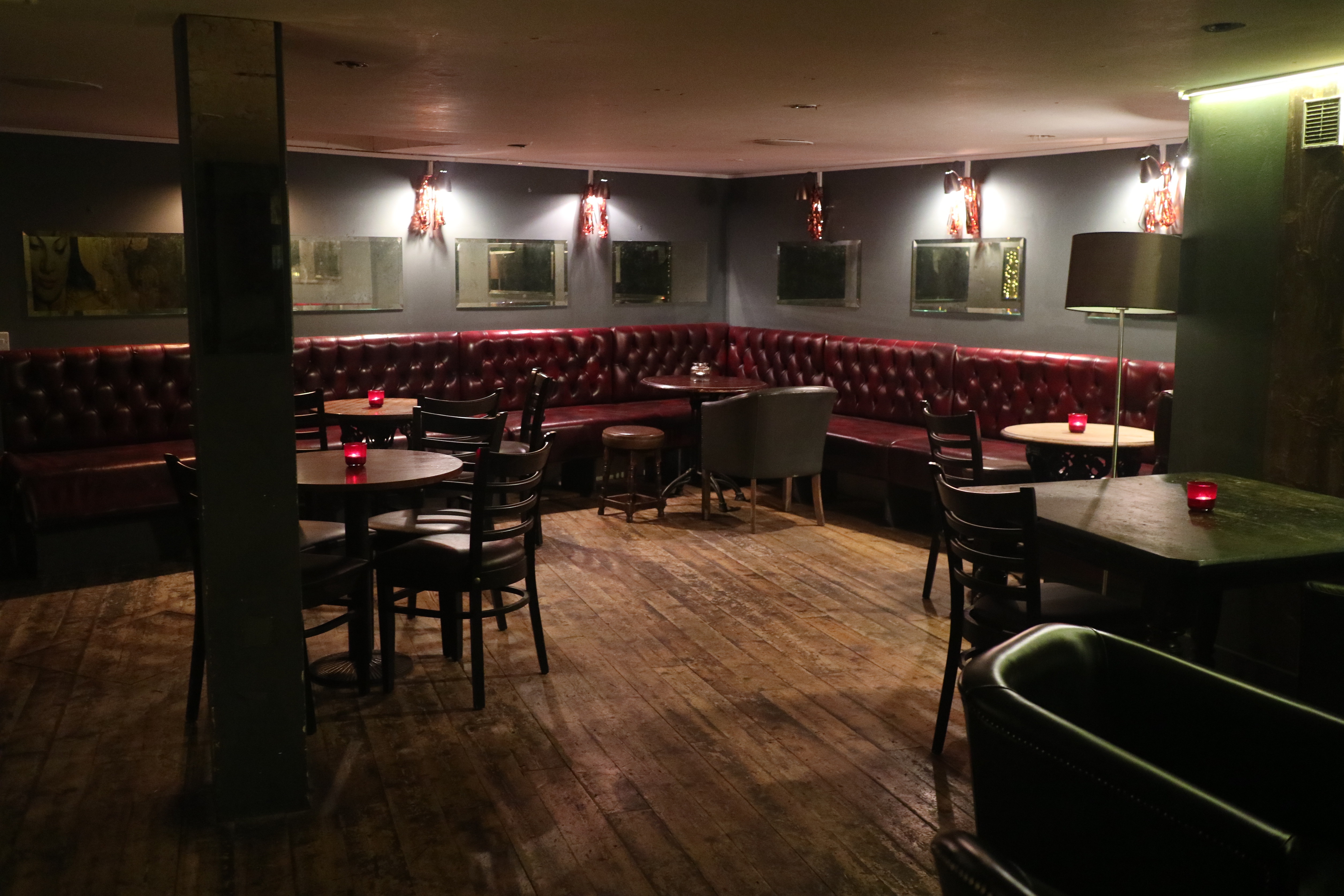 Intimate basement space with leather banquettes, ideal for networking events and gatherings.