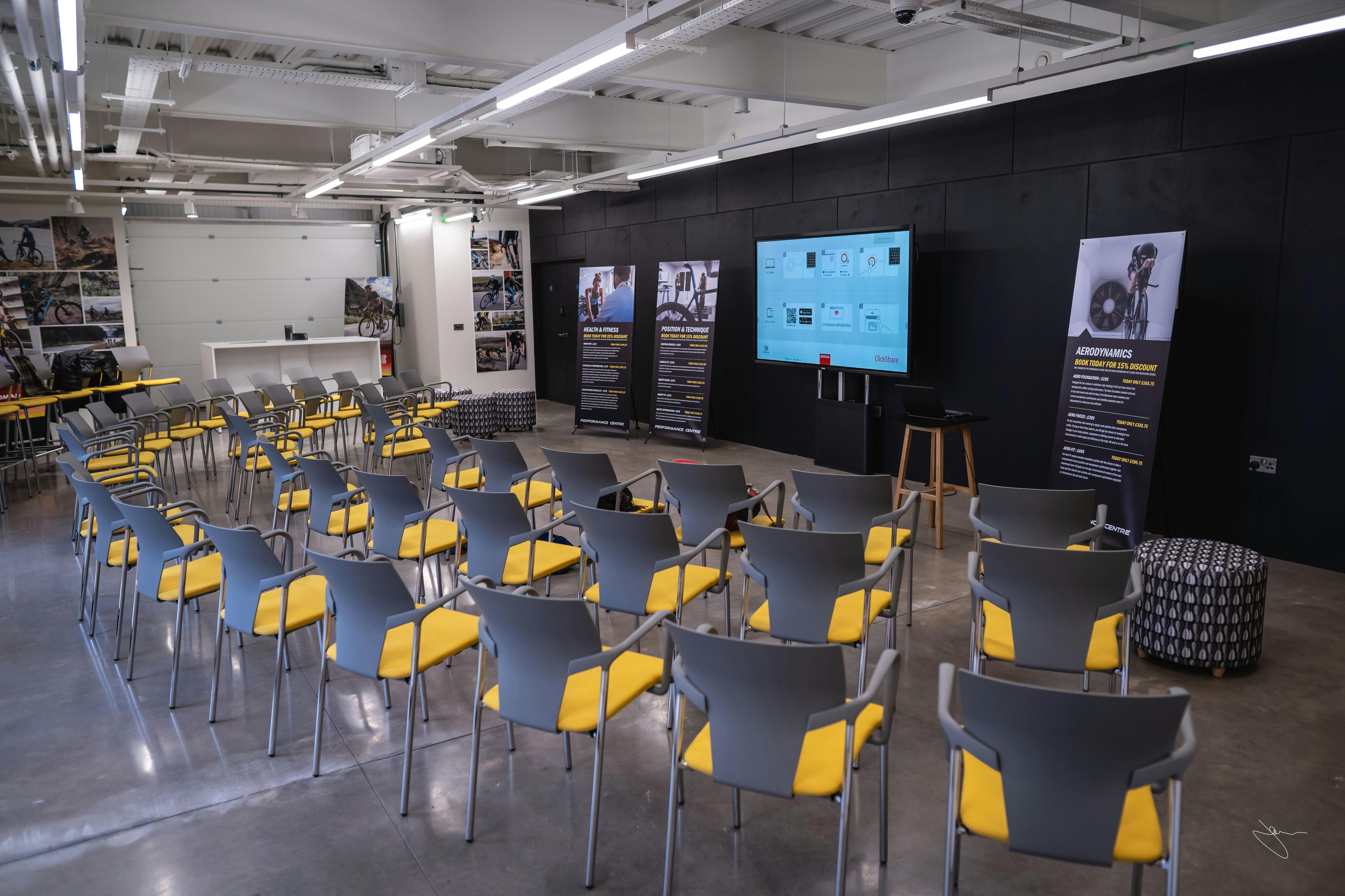 Ground Floor Event Space with gray chairs, ideal for presentations and meetings.