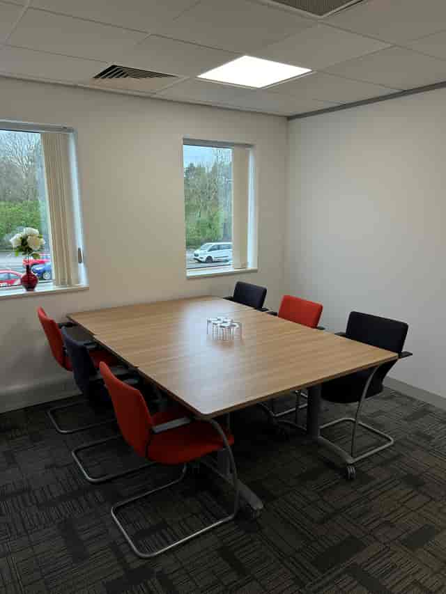 Red Suite at UBC Warrington: modern meeting room with vibrant chairs for brainstorming sessions.