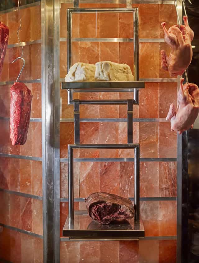 Upscale GRILL display with hanging meats and salt blocks for gourmet events.