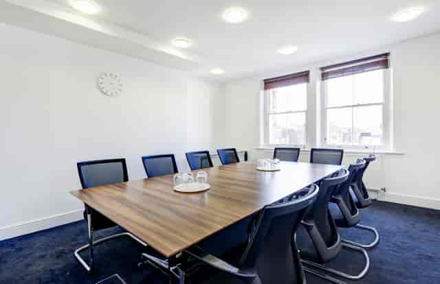 Modern conference room with wooden table, ideal for professional meetings and events.