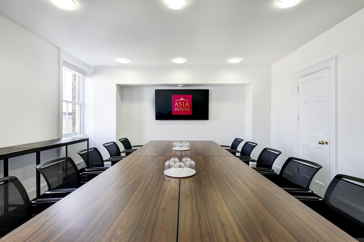 Modern conference room in Asia House with sleek table, ideal for meetings and presentations.