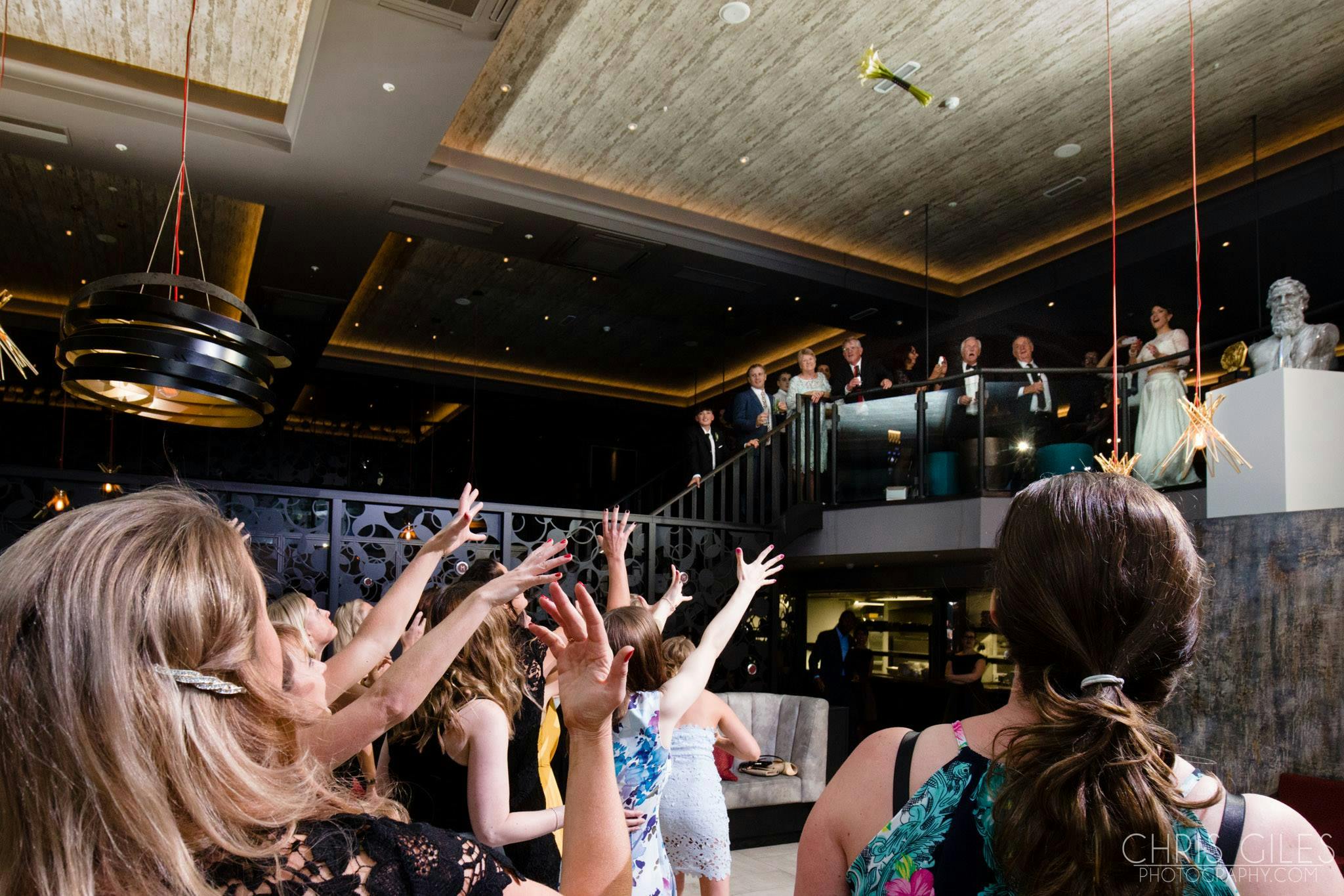 Lively bouquet toss at M BAR, upscale decor, event celebration in London.