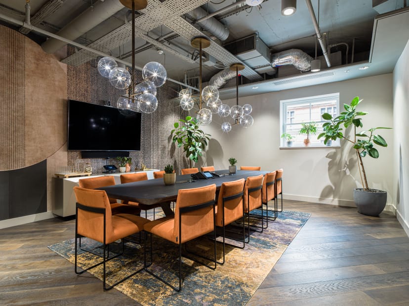 Modern conference room with wooden table and stylish orange chairs for meetings.