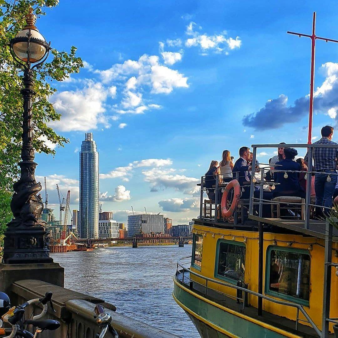 Vibrant outdoor event on Tamesis Dock's West-Facing Deck with skyline views.